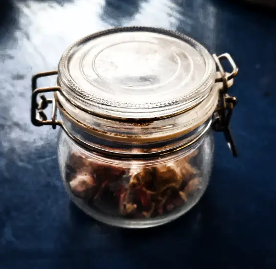 dried hot peppers stored in a glass jar